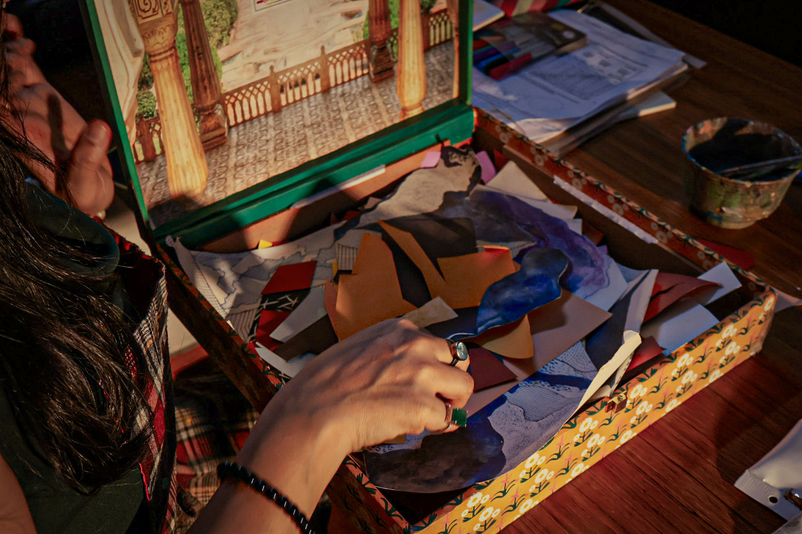 Shivani Garg sorting coloured paper fragments from an open decorated box