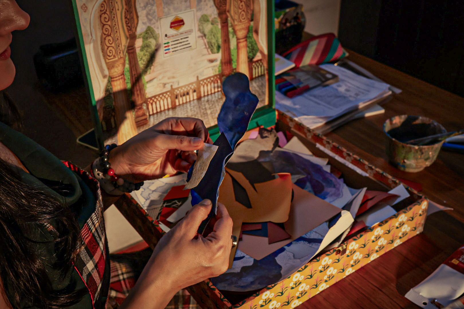 Coloured paper and tools spread across the studio desk