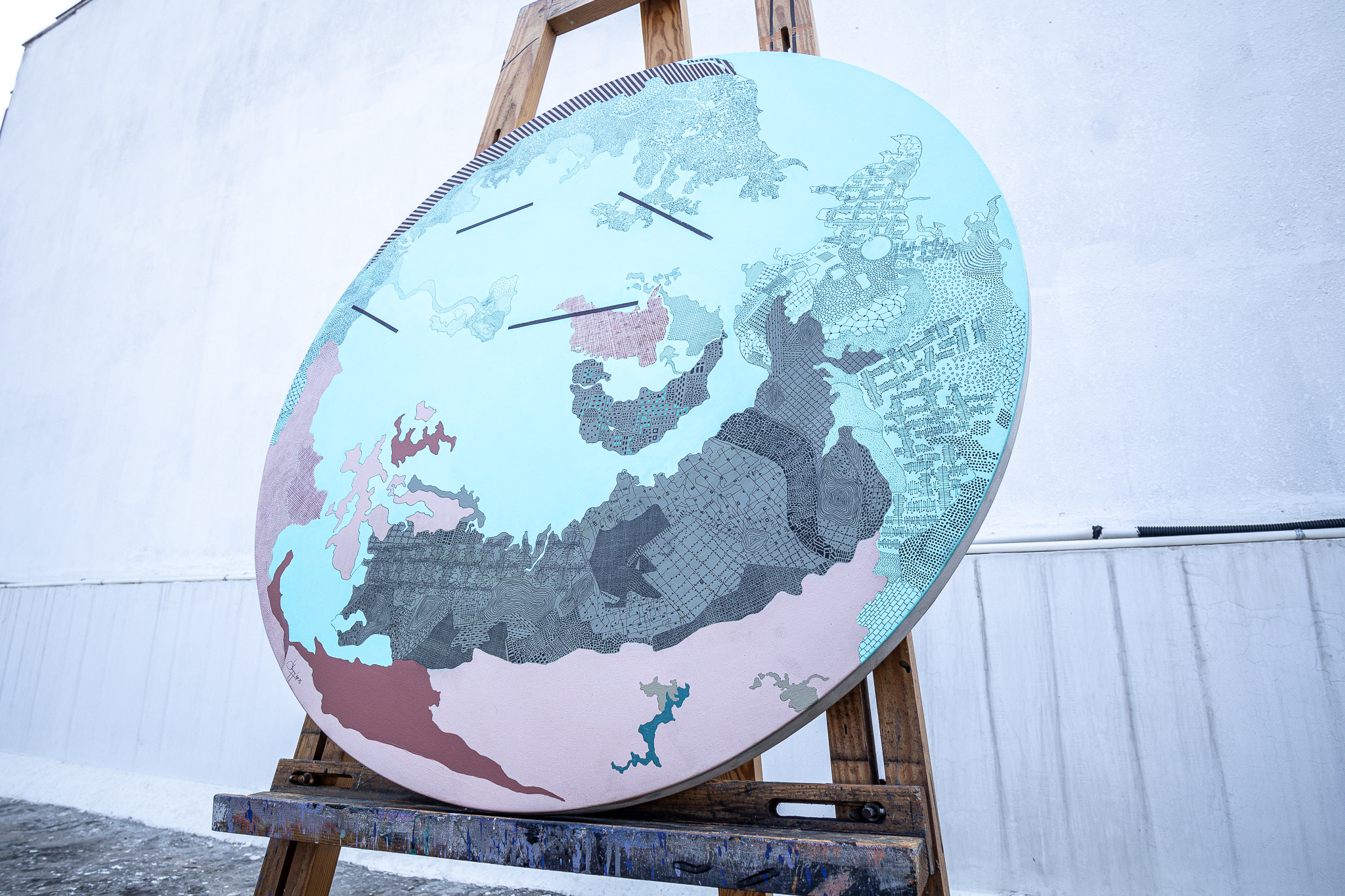Turquoise circular artwork on an easel, shown in full